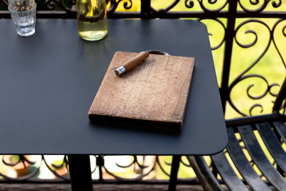 old wooden cutting board on the rectangular top of the Donut bistro table for an outdoor aperitif