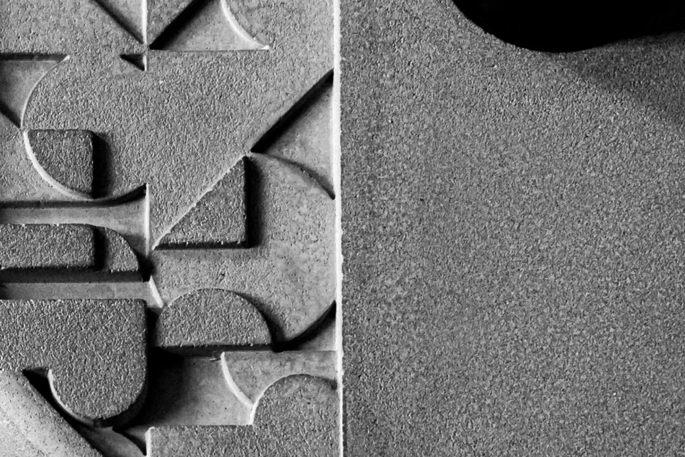 mix of Brutalism and Bauhaus design for the low relief pattern carved in the concrete base