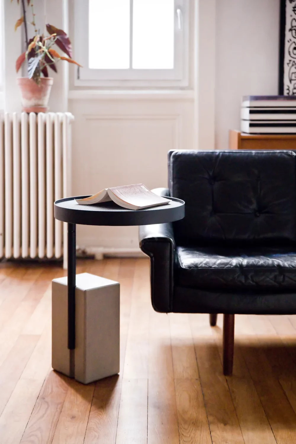 The pedestal table in concrete and wood adapts to the height of your sofa thanks to the two possible heights of its swivelling plateaux