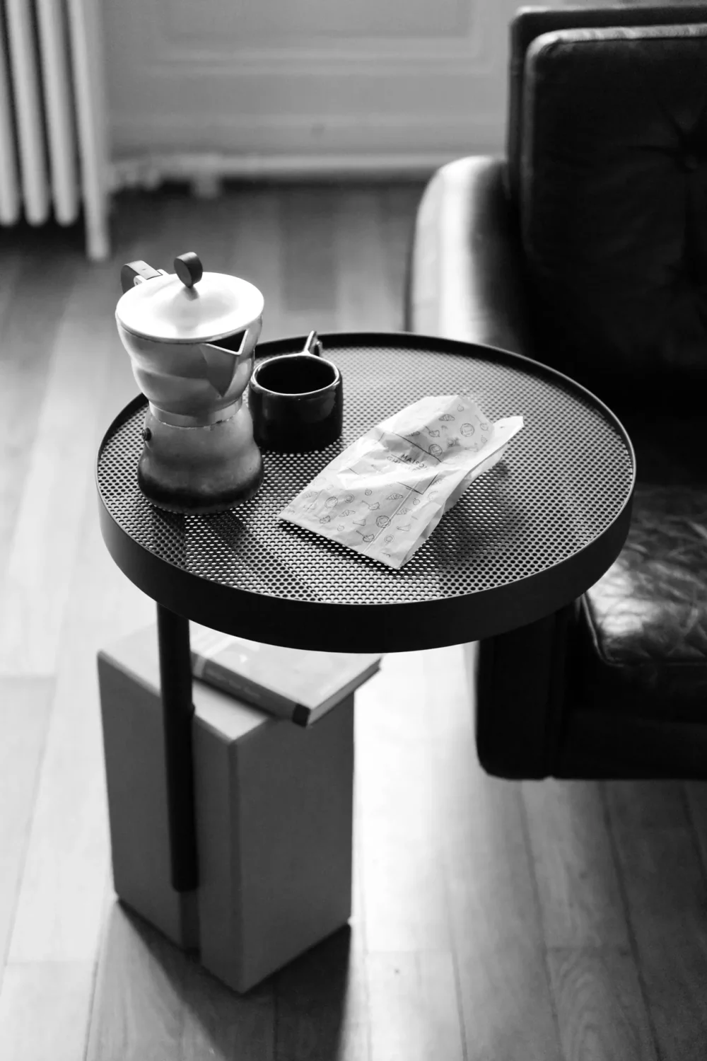 Black and white picture of the Twist pedestal table on which is placed a vintage coffee pot