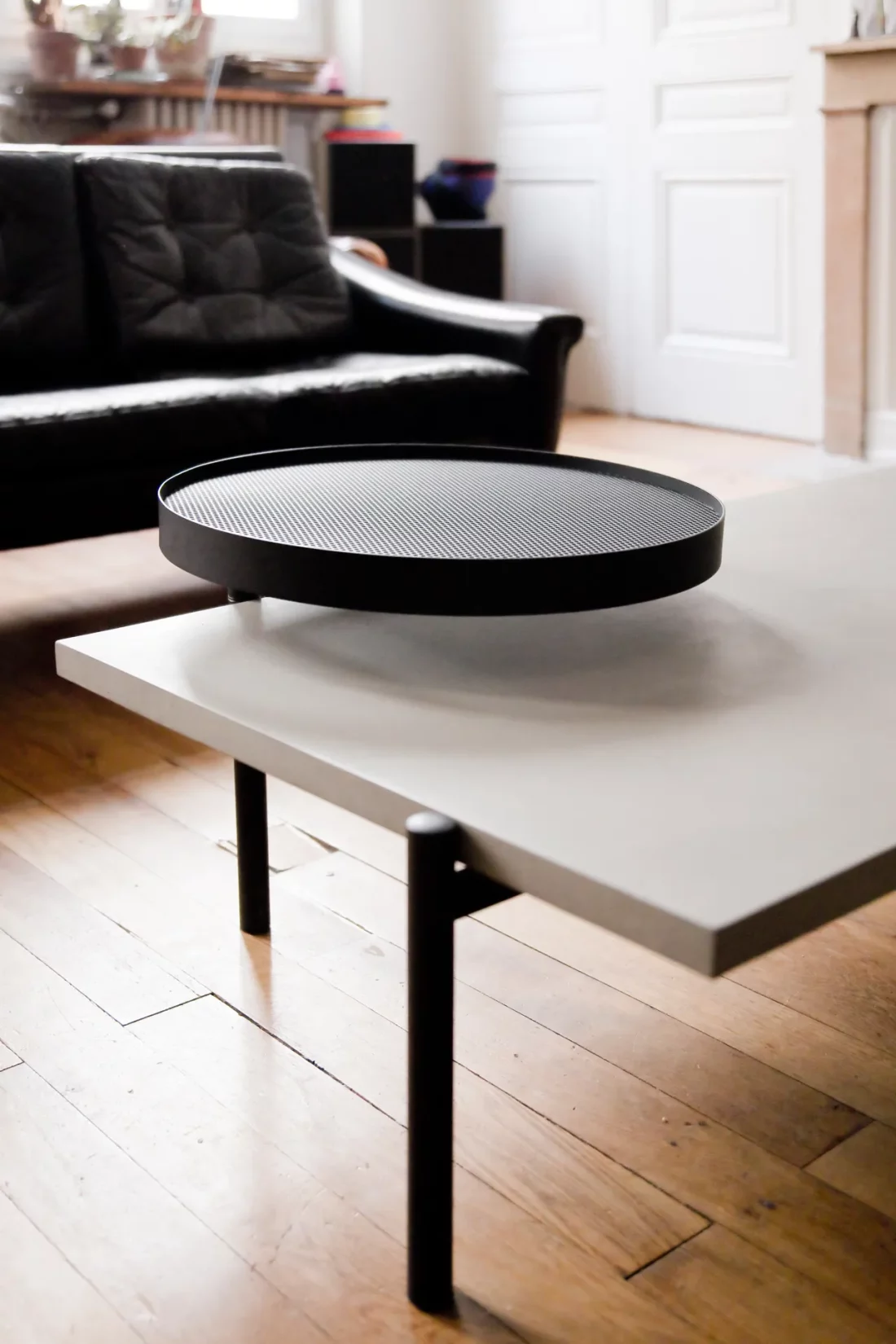 The Twist coffee table with its concrete top and its second black metal top fits perfectly in a Haussmannian apartment